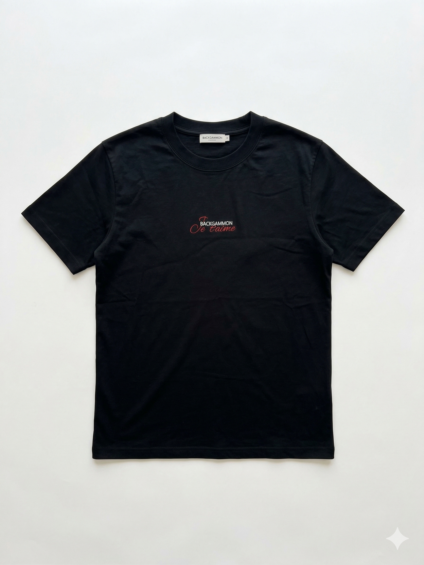 Flat lay of the black Backgammon Je t'aime T-shirt with embroidered red script logo on the chest