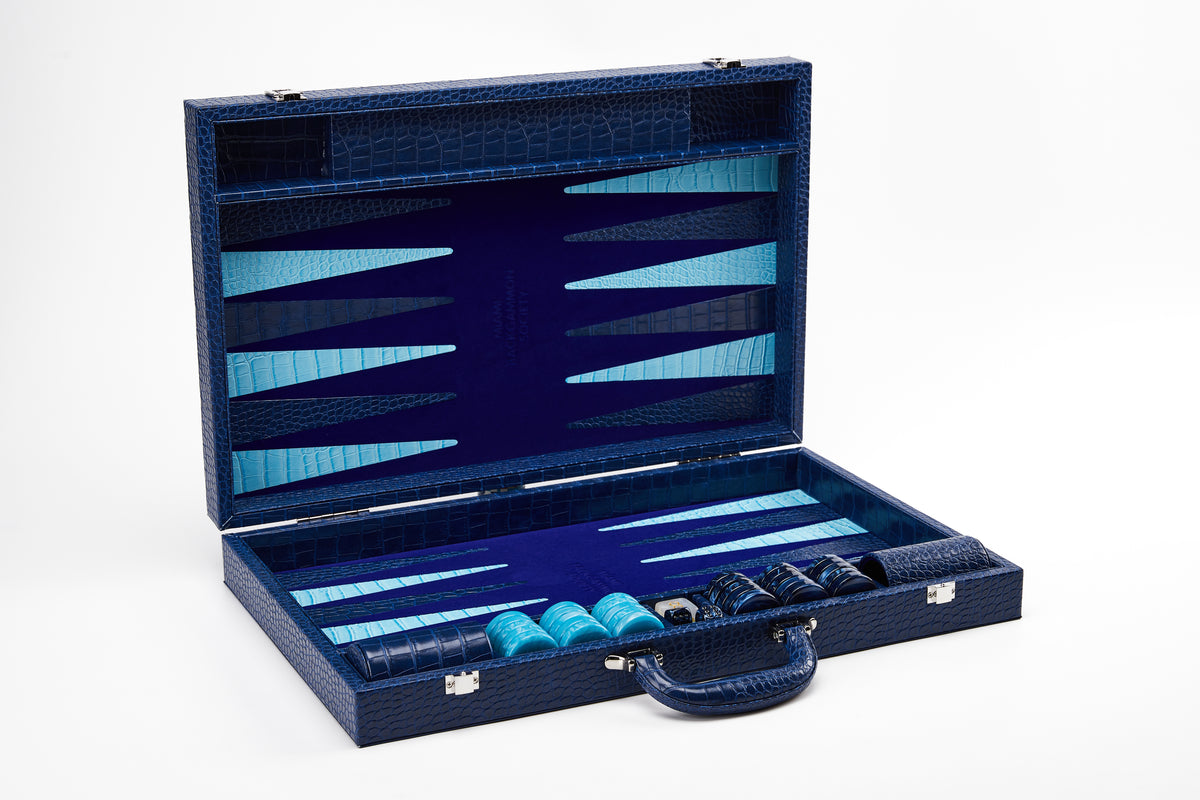 Straight-on view of open Midnight Navy crocodile-embossed backgammon case standing upright with checkers stacked in the side tray