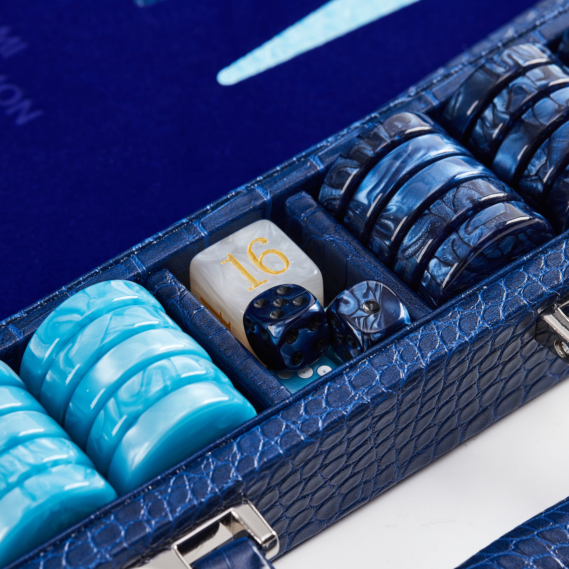 Close-up of navy and cyan checkers, dice, and doubling cube showing the number 16 inside the Midnight Navy backgammon case tray