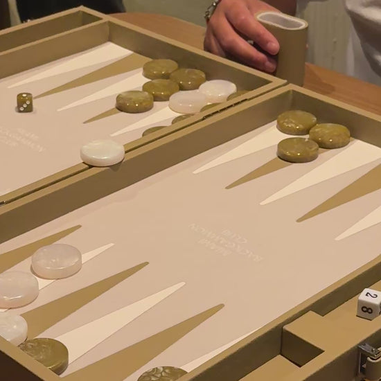 two men playing backgammon with the miami backgammon club's beige board
