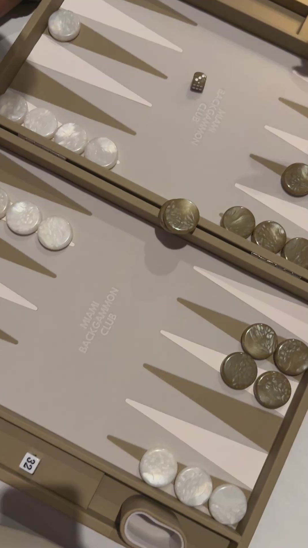 people playing backgammon on the miami backgammon club beige board