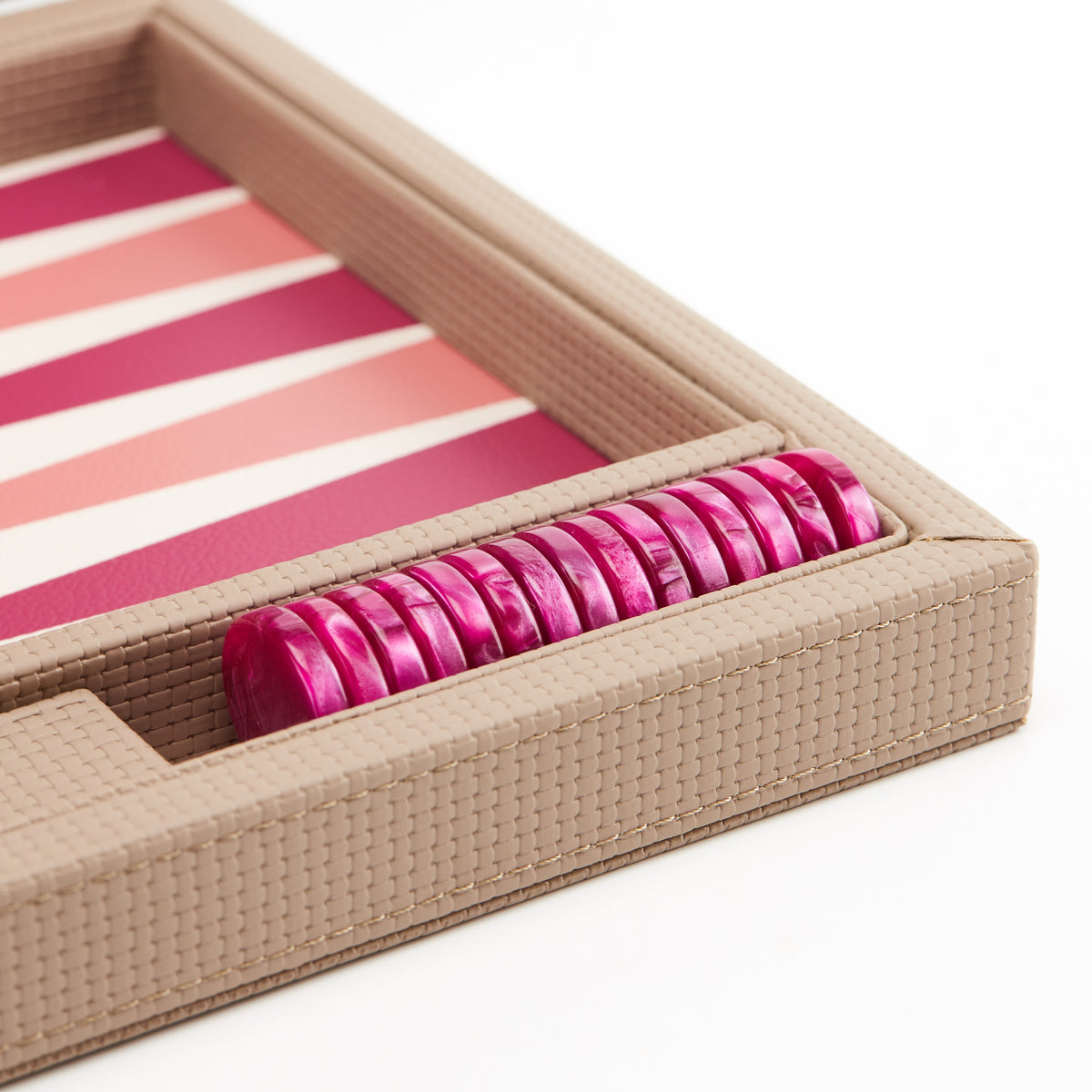 Magenta checkers stacked in the side tray of the beige board
