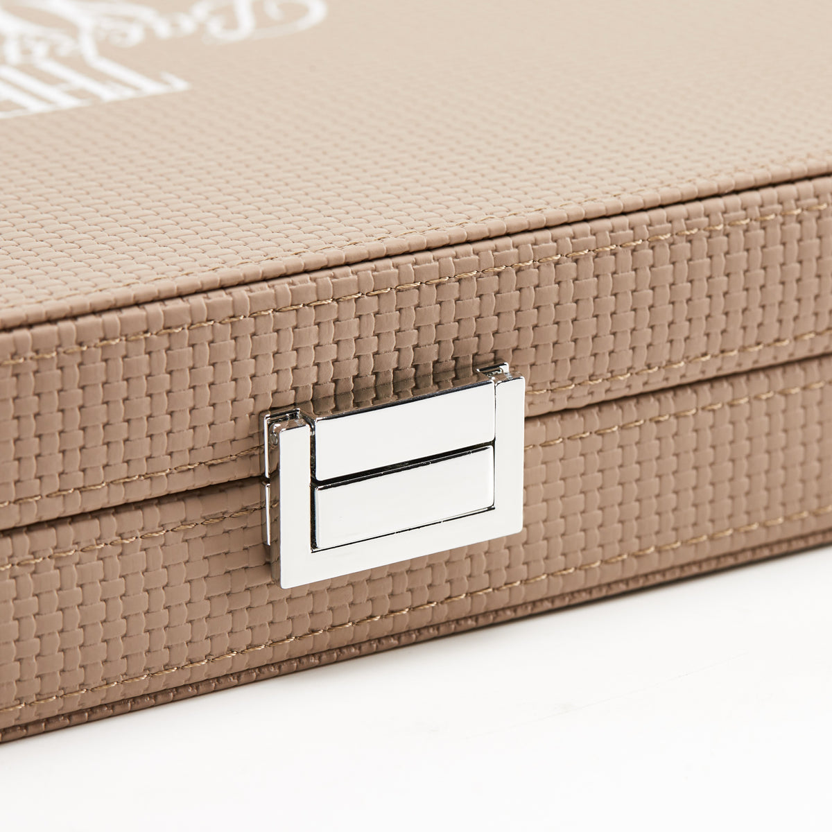 Close-up of the silver-tone clasp on the woven sand leather case