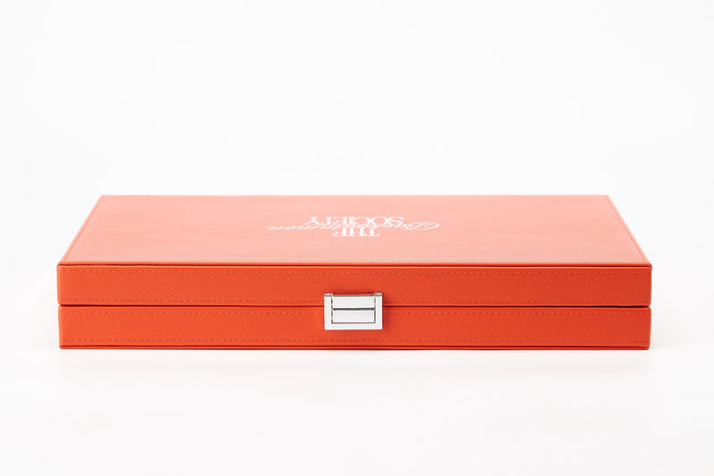 The Backgammon Society Board in coral orange grained leather, closed, front view