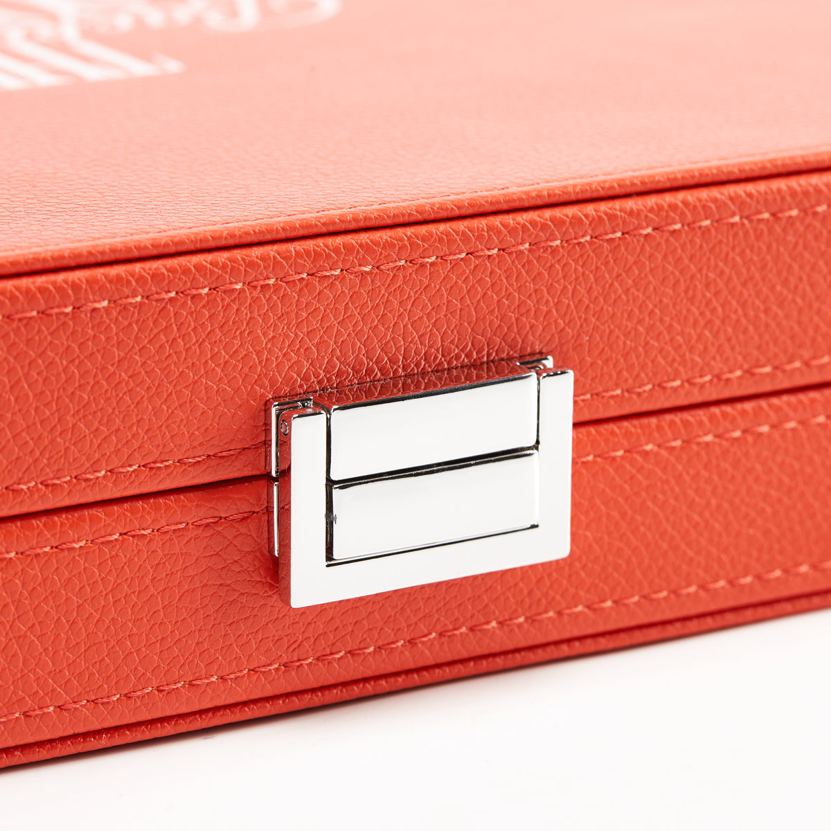 Close-up of the silver-tone clasp on the coral orange leather case