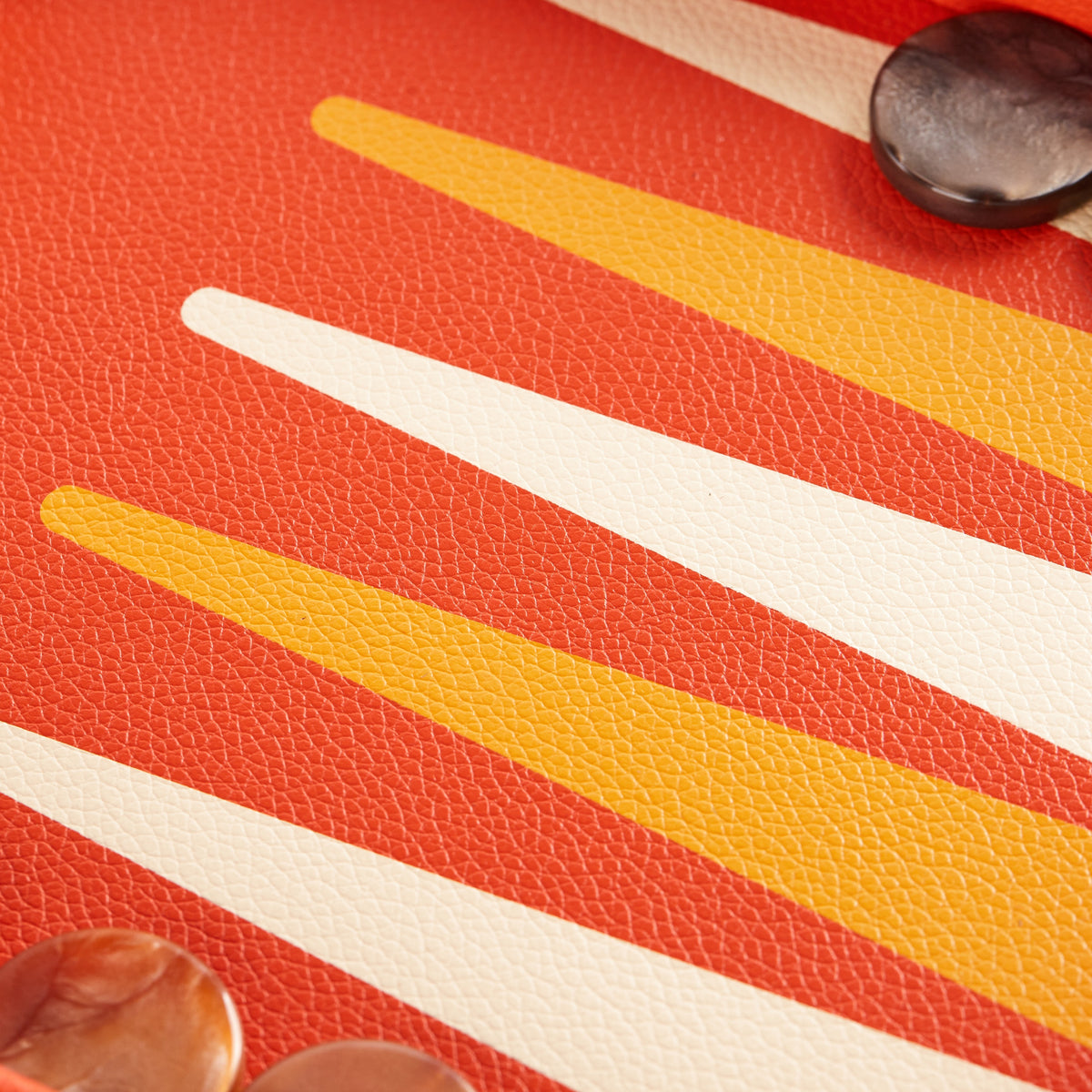 Close-up of ivory and golden playing points on the orange field
