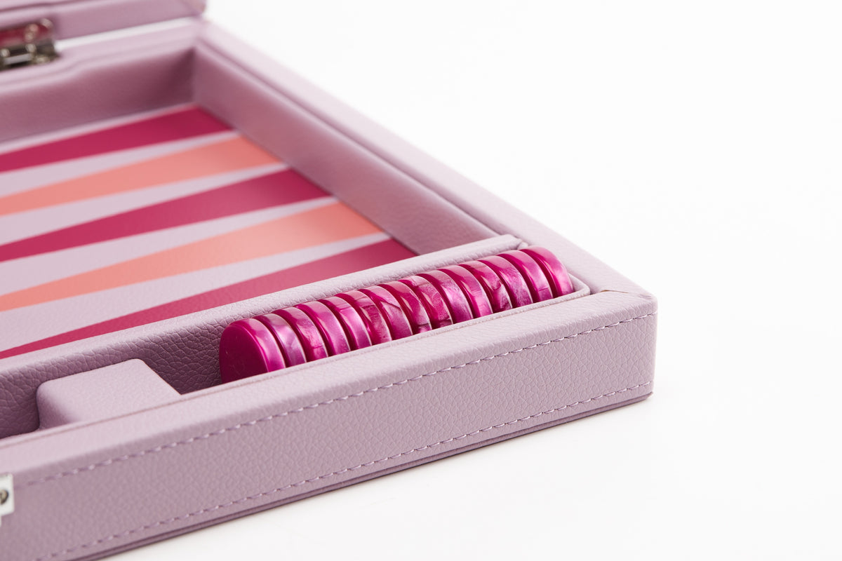 Fuchsia checkers stacked in the side tray of the pink board