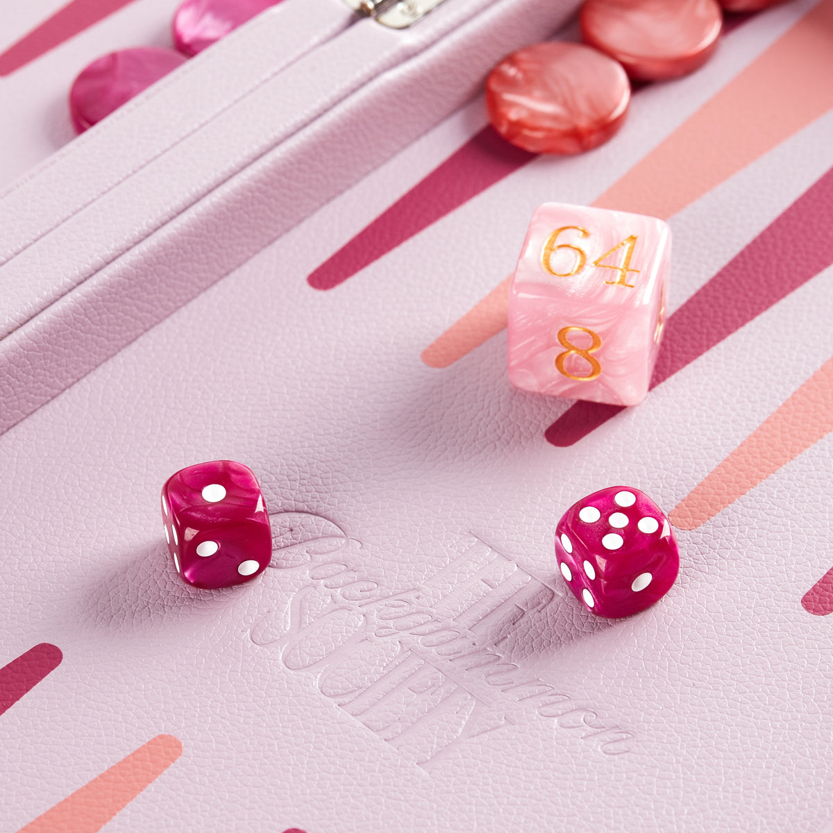 Dice and the coral doubling cube resting on the lilac playing field